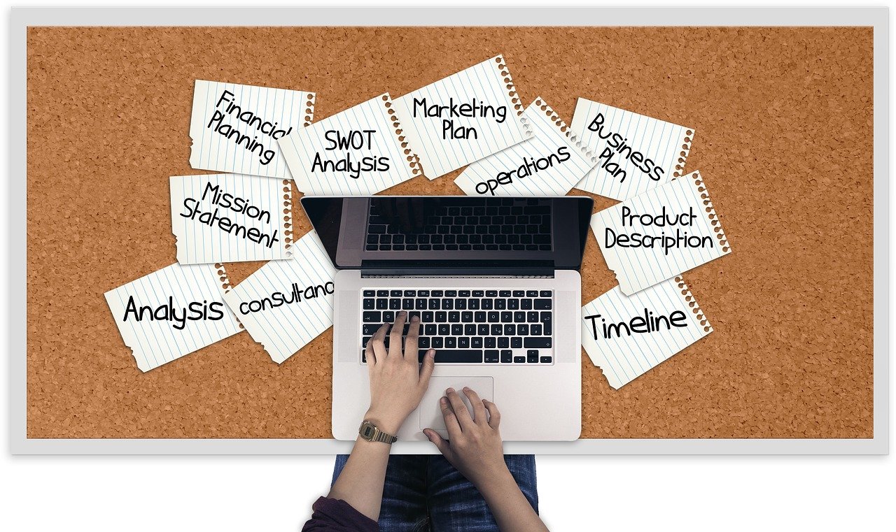 desktop of a dance studio owner writing a dance studio business plan and piles of papers with analysis mission statement swot analysis 