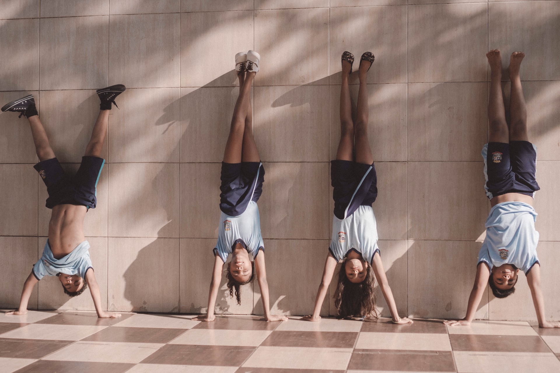 Four gymnasts doing a handstand in gymnastics business