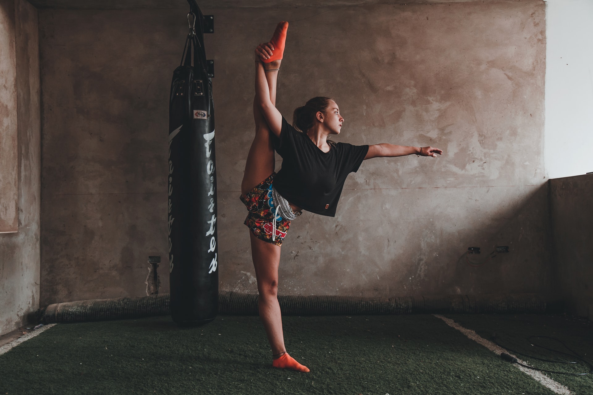 Woman in gymnastics business doing a split while standing on one leg